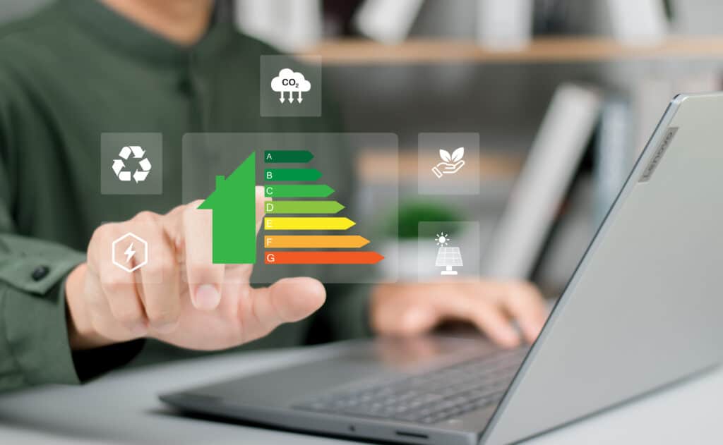Efficacité Énergétique Maison : Classement A à G et Écologie Main pointant une icône de maison avec étiquette de classe énergétique A-G, entourée d'icônes écologiques (CO2, recyclage, énergie, solaire).